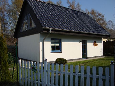 Außenansicht des Ferienhauses mit weißem Gartenzaun