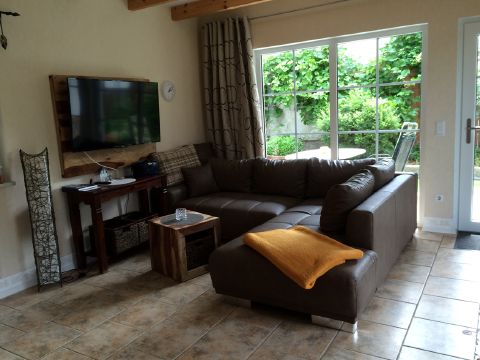 Wohnzimmer mit Ecksofa und Flachbild-TV